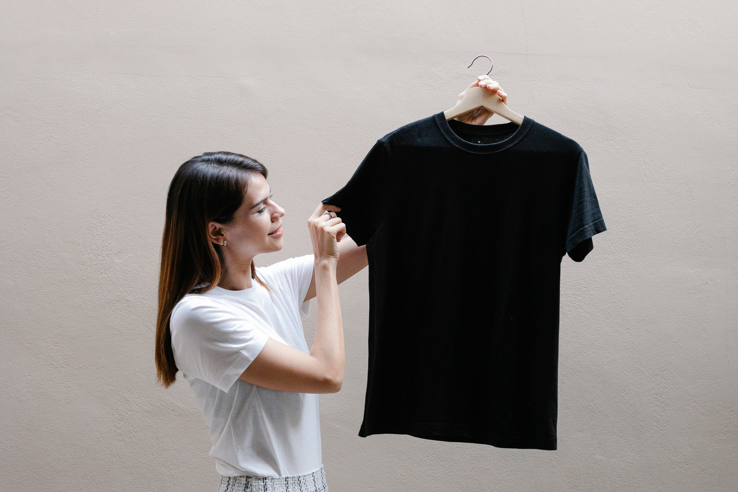 Smiling woman showing t shirt on hanger
